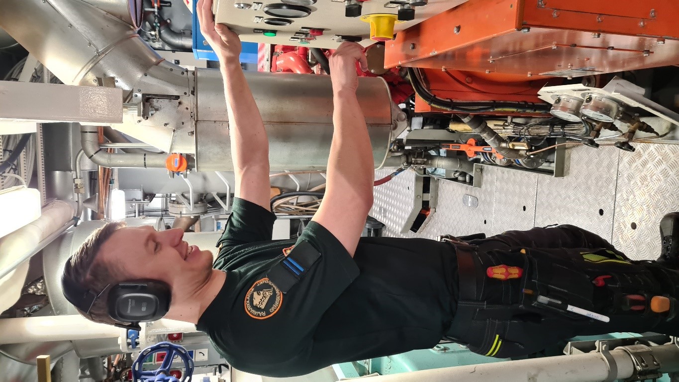 En elektriker jobbar i fartygets maskinrum.