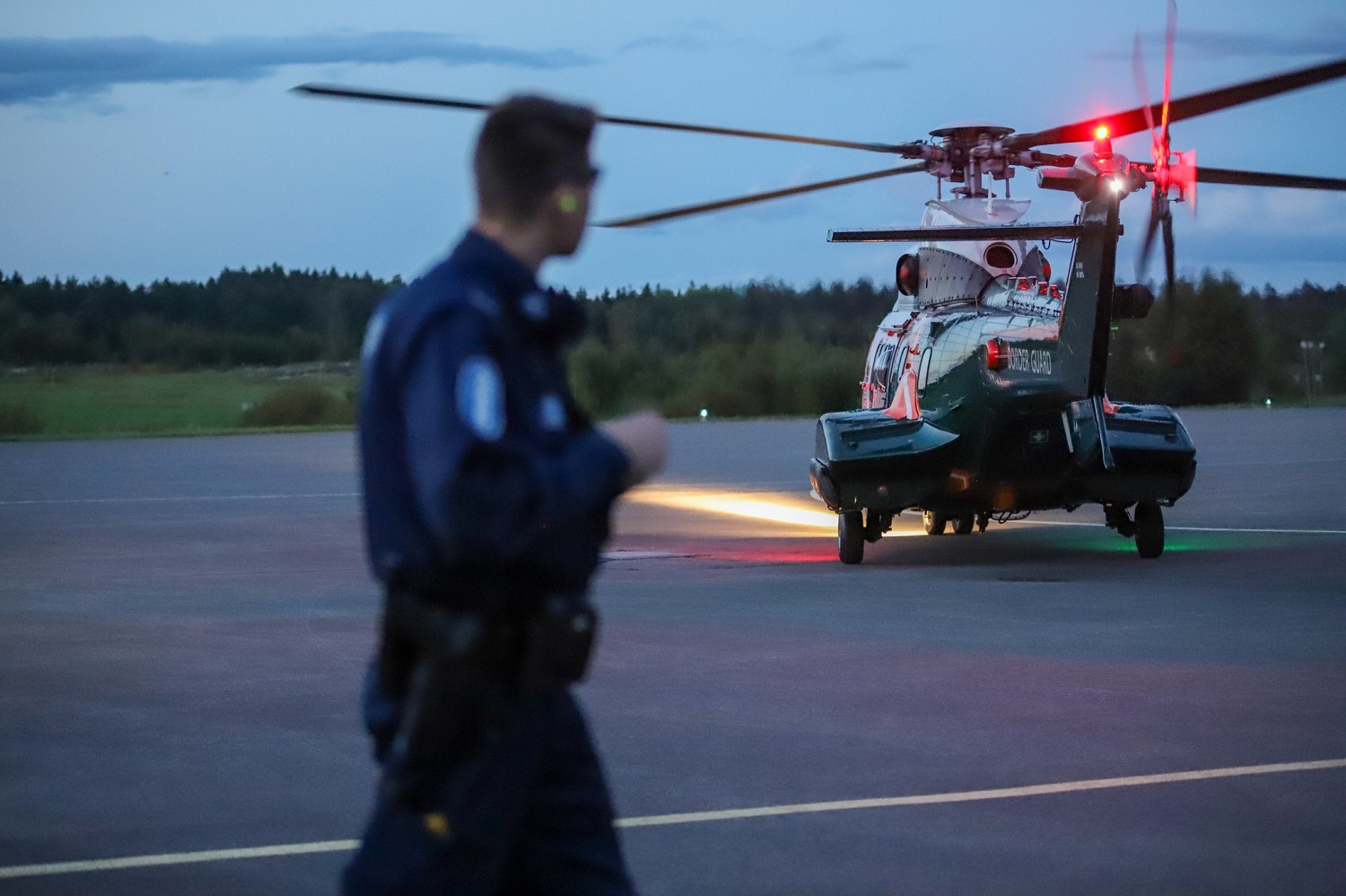 En helikopter och en polis på flygplatsen.