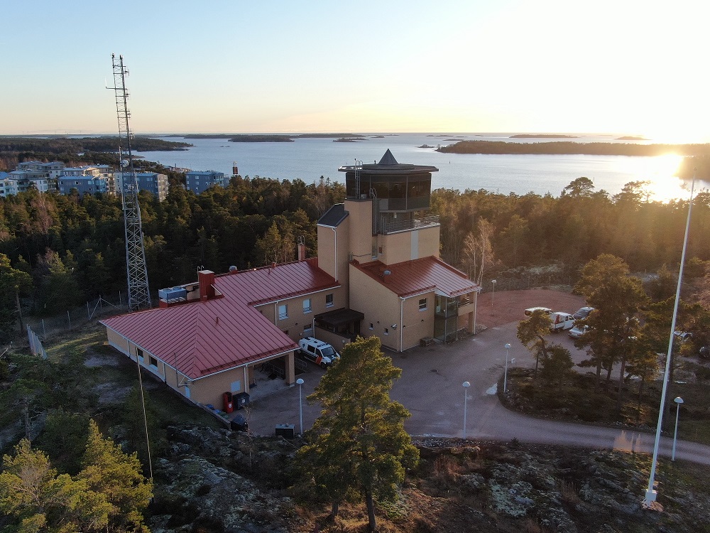 Ålands sjöbevakningsstation från uppåt.  Det är kväll, solen skiner, det finns skog omkring. 