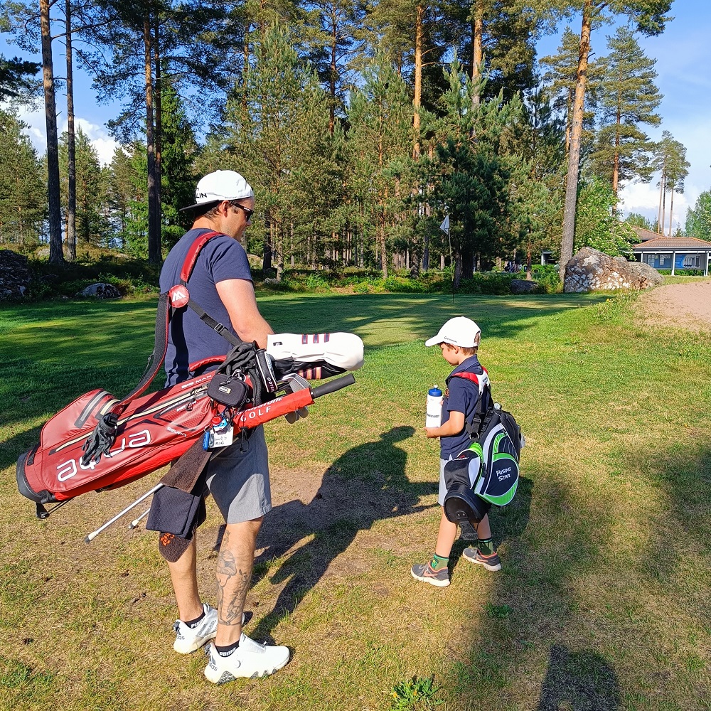 Isä ja poika golfkentällä.