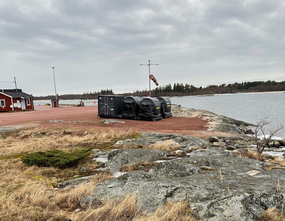 Öljyntorjunnan välinekontti meren rannassa.