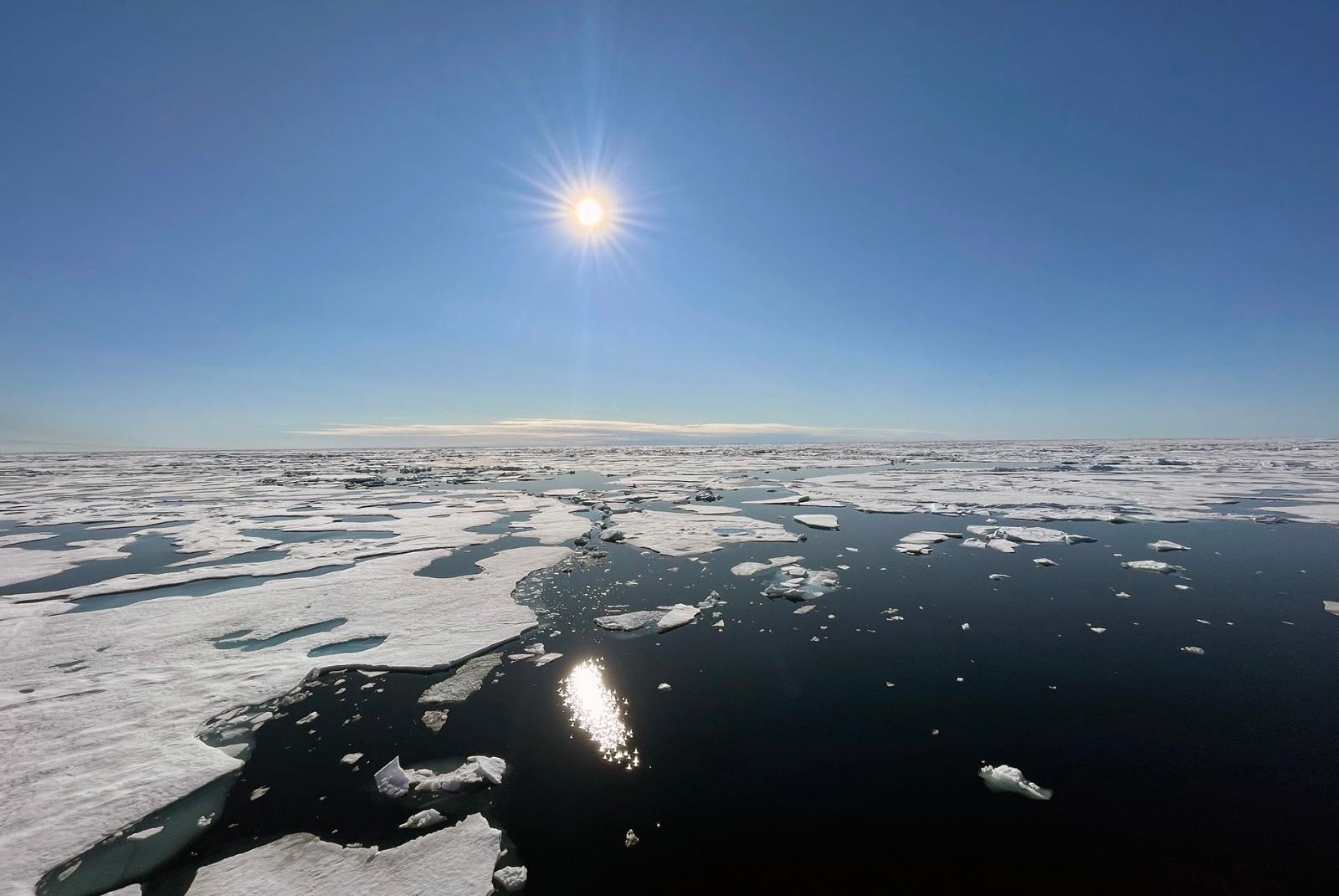 Ilta-aurinko paistaa jäisen meren yläpuolella Pohjoisella jäämerellä. 