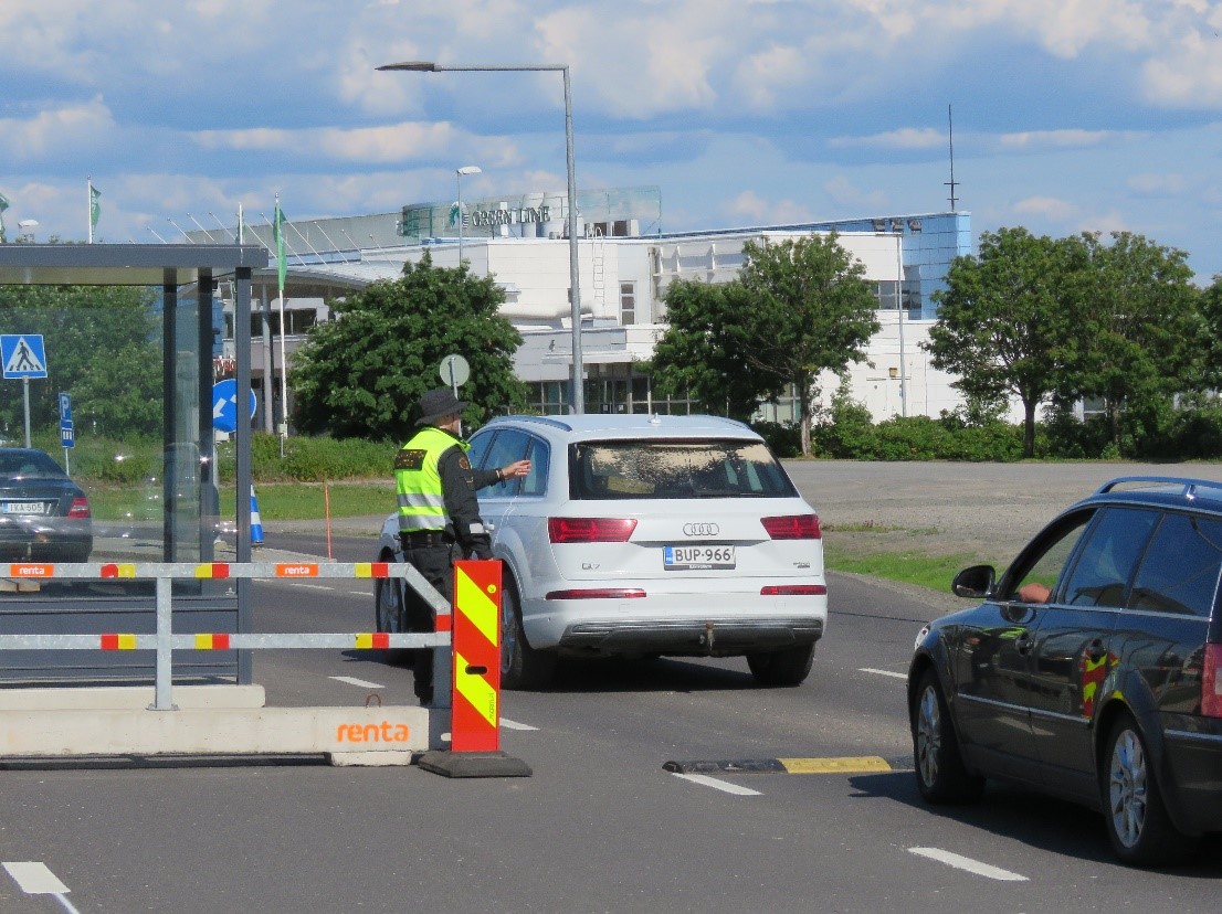 En gränsbevakare kontrollerar bilar vid ett gränsövergångställe.