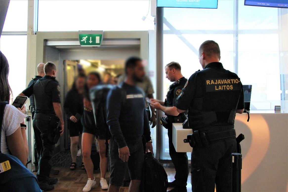Två gränsbevakare utför kontrollen vid utgången på flygplatsen.