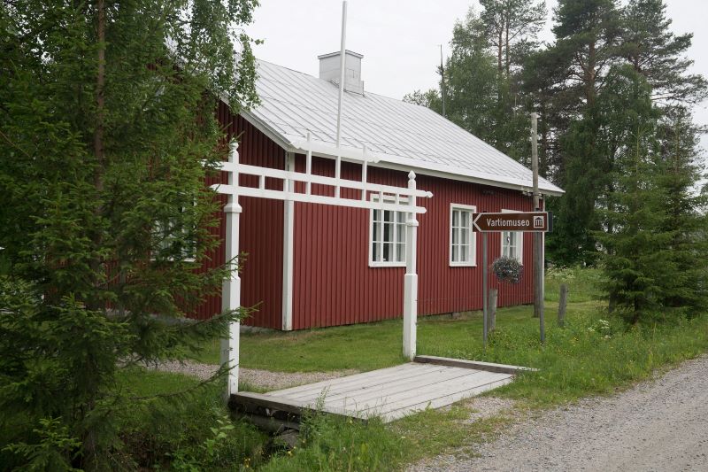 Den röda museebyggnaden i skogen i nutiden.