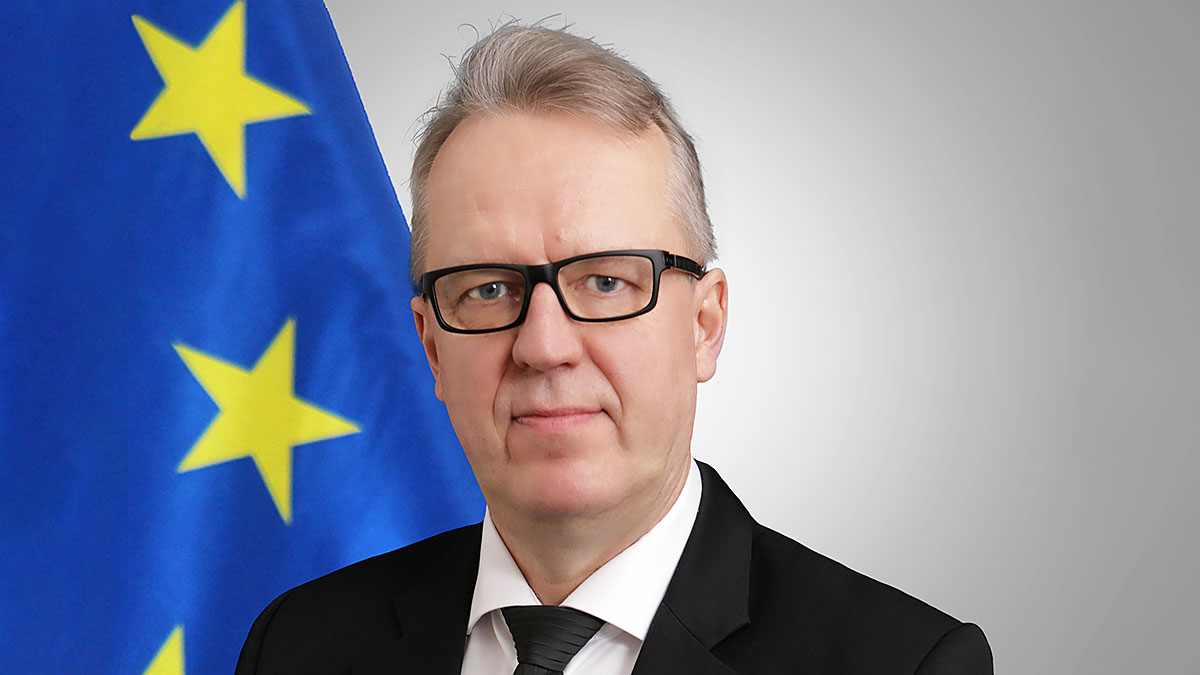 Antti Hartikainen. Taustalla EU:n lippu.
