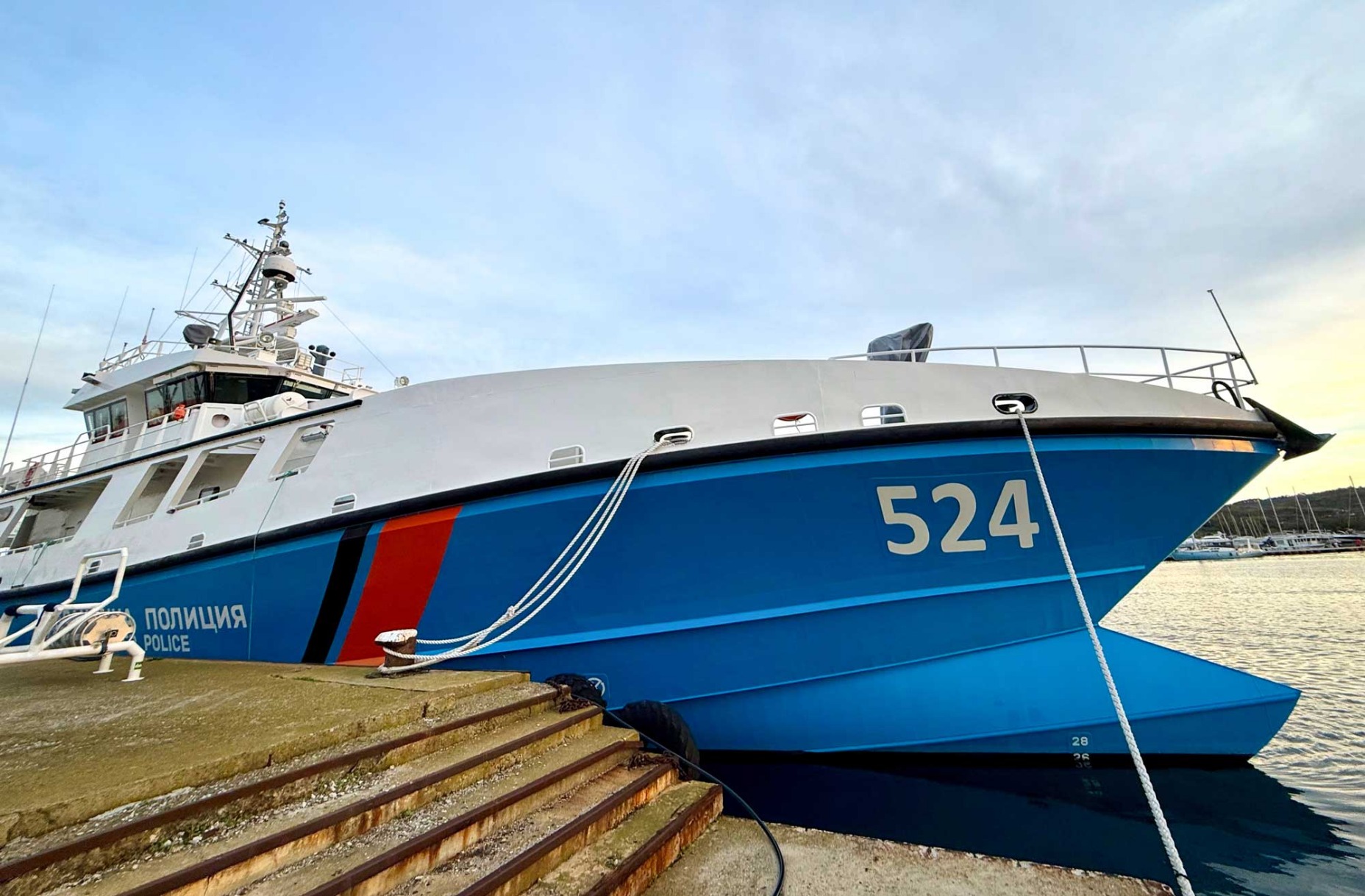 Bulgarian rajapoliisin merellisen kaluston lippulaiva ”Balchik” kelluu laiturissa. Takana aurinkoinen merimaisema.