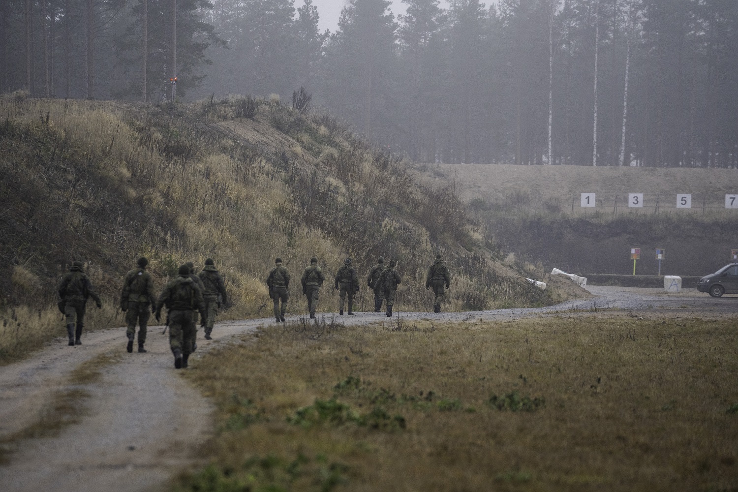 Erikoisrajajääkärikokelaat kävelelvät ampumaradalla. Kuva takaapäin.