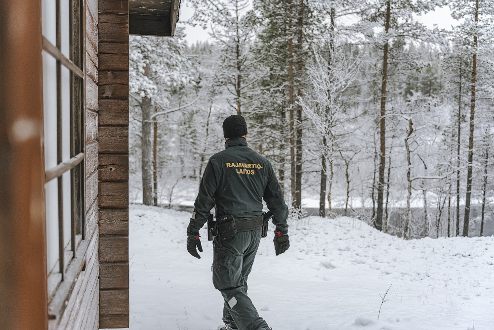 Rajavartija kuvattuna selästä päin talvisessa maisemassa.