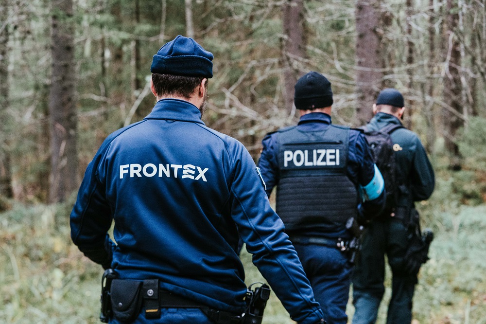 Frontex-virkamiehet kävelemässä metsässä.