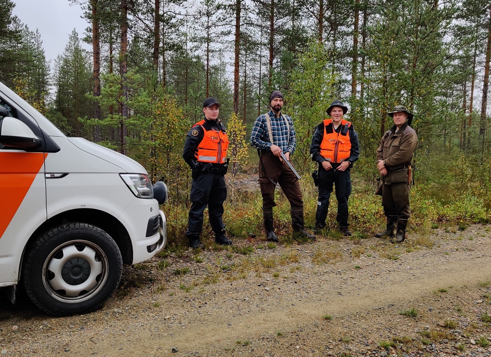 En gruppbild av jägare och jakt övervakare. 