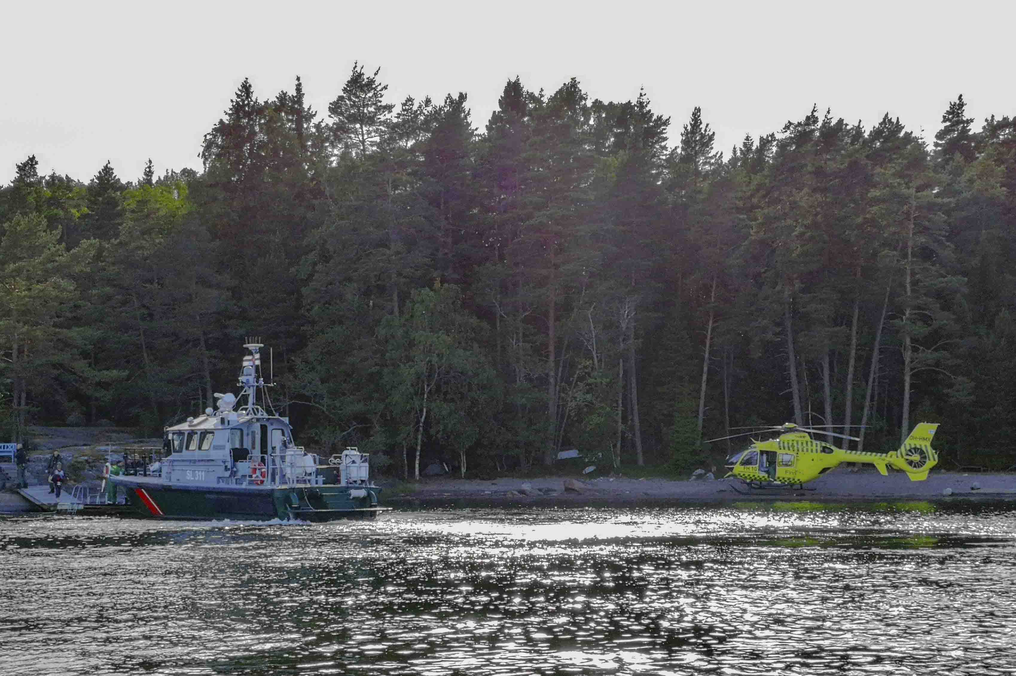 Rajavartiovene ja helikopteri rannassa.