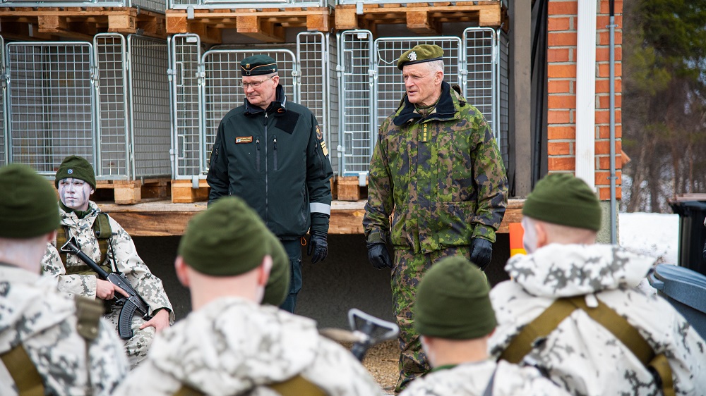 Rajavartiolaitoksen päällikkö ja Puolustuvoimien komentaja seisovat vierekkäin. Etualalla varusmiehiä.