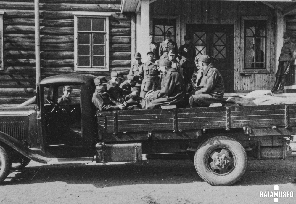 En gammal bild om gränsbevakare som sitter i en lastbil.