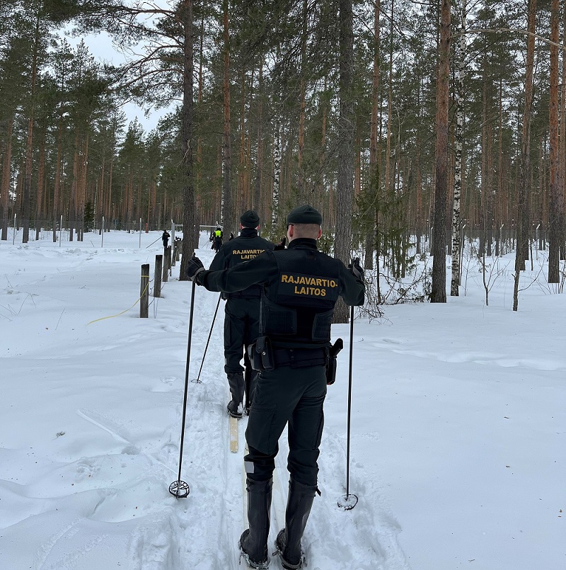 Rajavartijaopiskelijat hiihtämässä jonossa. Kuva otettu takaapäin.