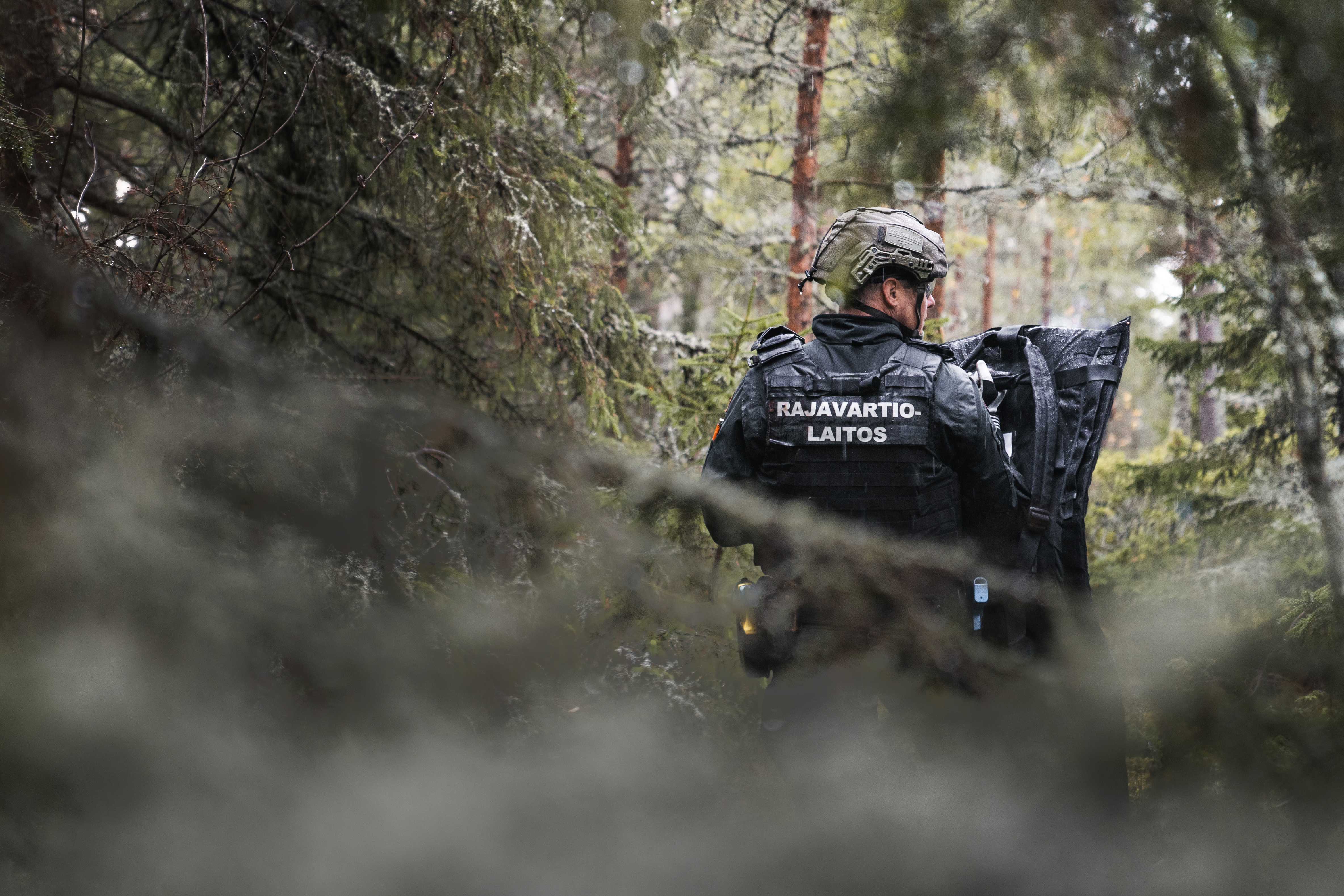 Merivartija kävelee metsässä selkä kohti kameraa.