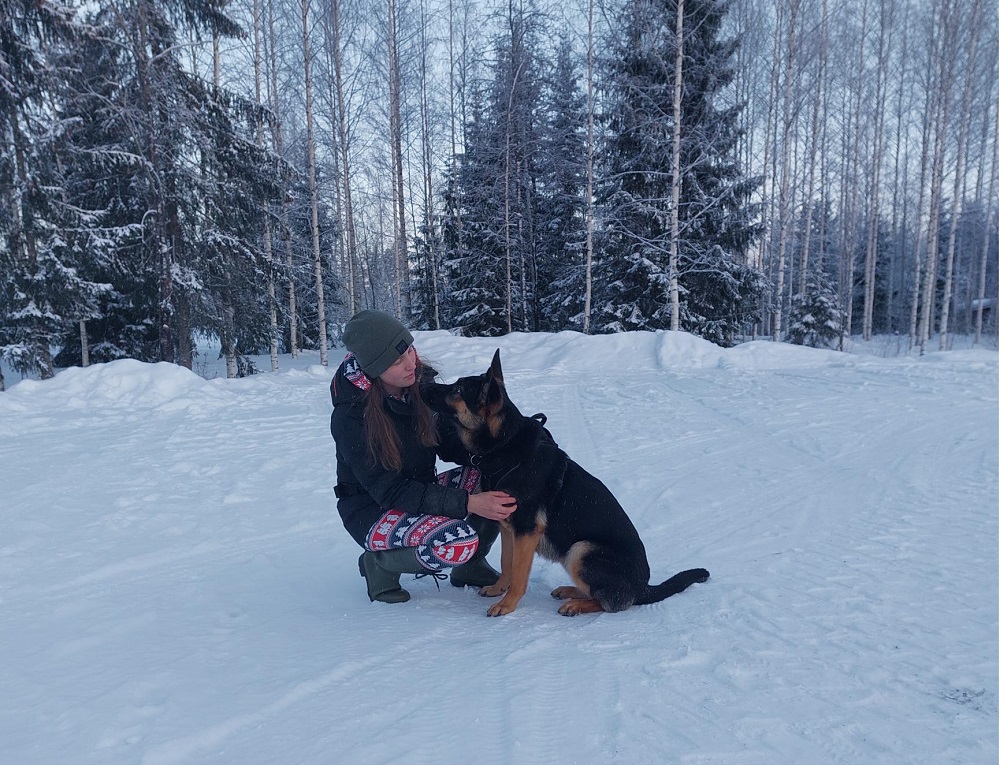 En gränshund och en människa i vinter. 