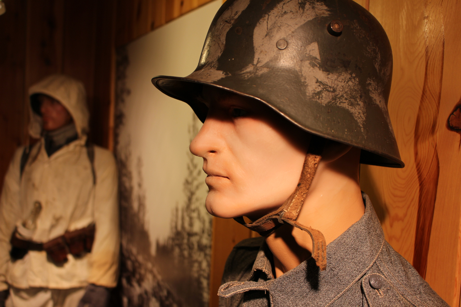 Sotilasnukker kypärä päässä Rajamuseossa. Taustalla toinen nukke lumipuvussa.